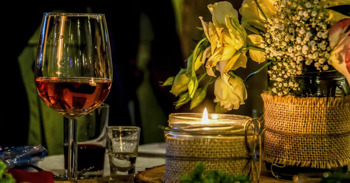 Table de mariage d'automne aux bougies, avec un verre de rosé et des fleurs jaunes